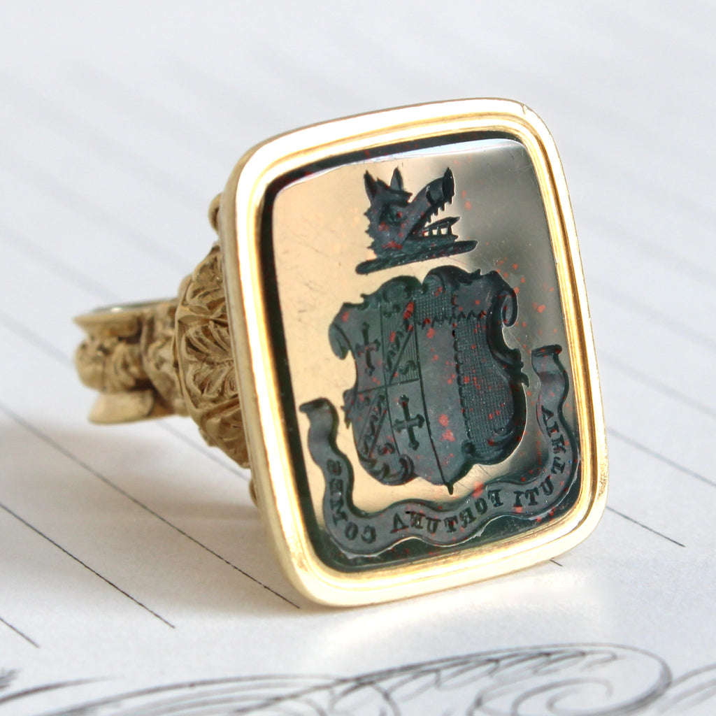  yellow gold wax seal with a fancy top and bloodstone intaglio carved with a boar's head and shield motif with a banner inscribed Virtuti Fortuna Comes