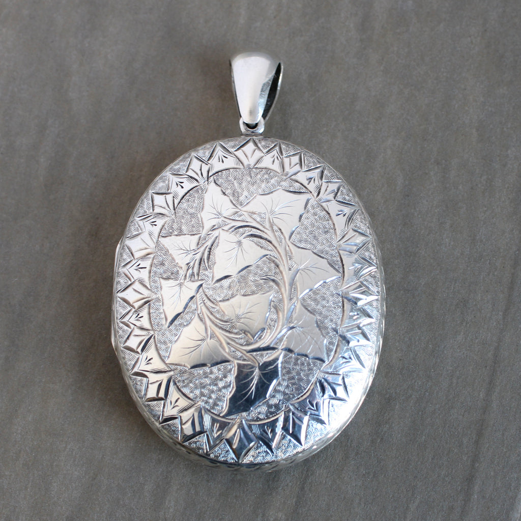 Vintage sterling silver large oval locket engraved with an ivy leaf motif on both sides.