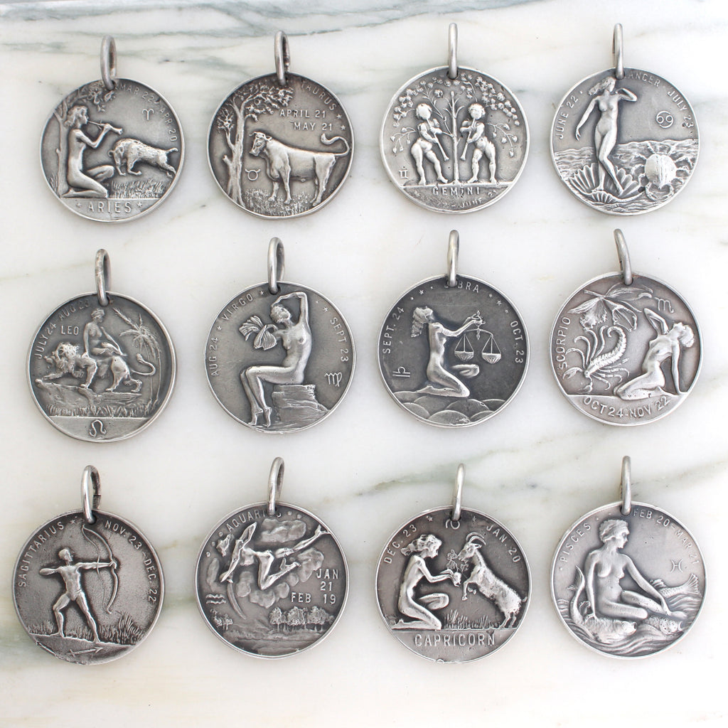 Assortment of sterling silver medallion coins with all twelve of the zodiac figures on each coin.