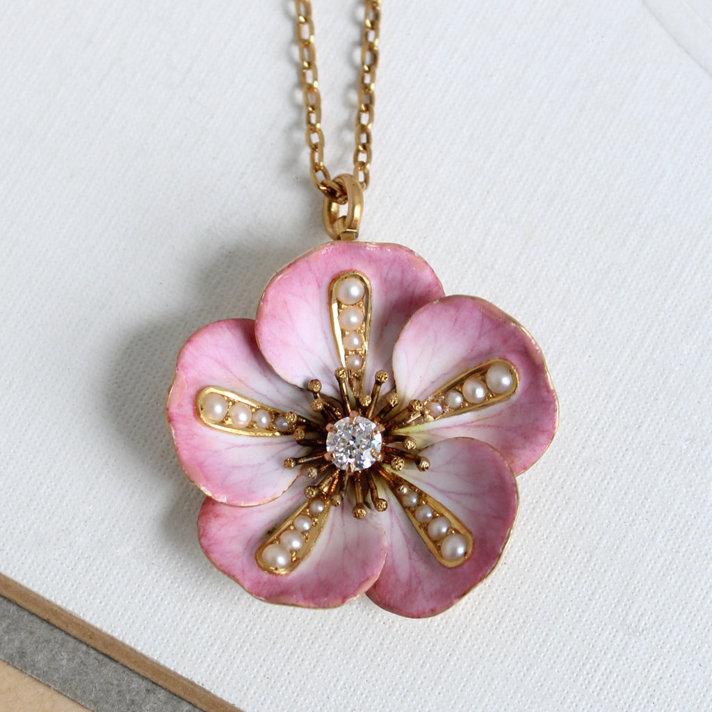 art nouveau enameled gold wild rose flower pendant in shades of pink with pearls and a diamond in the center