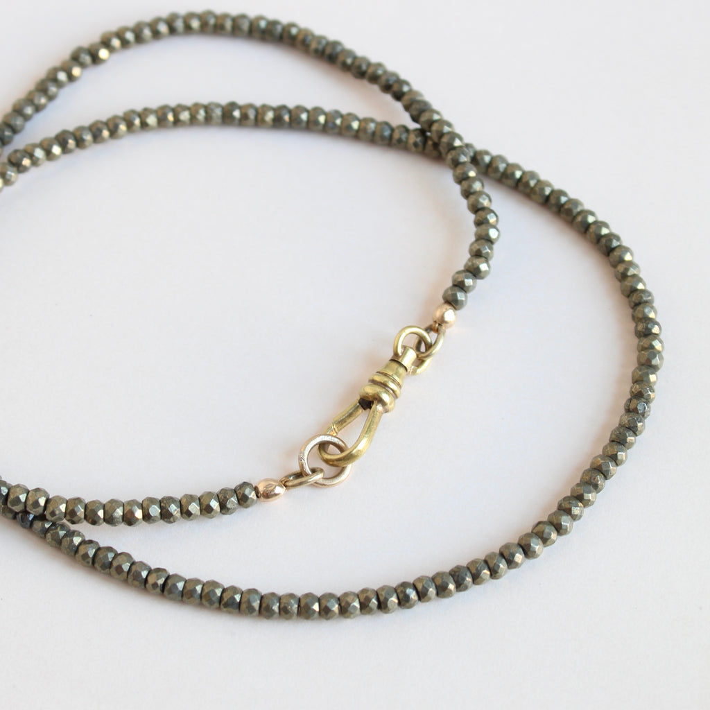 faceted pyrite bead necklace with yellow gold clip clasp that can also hold a pendant