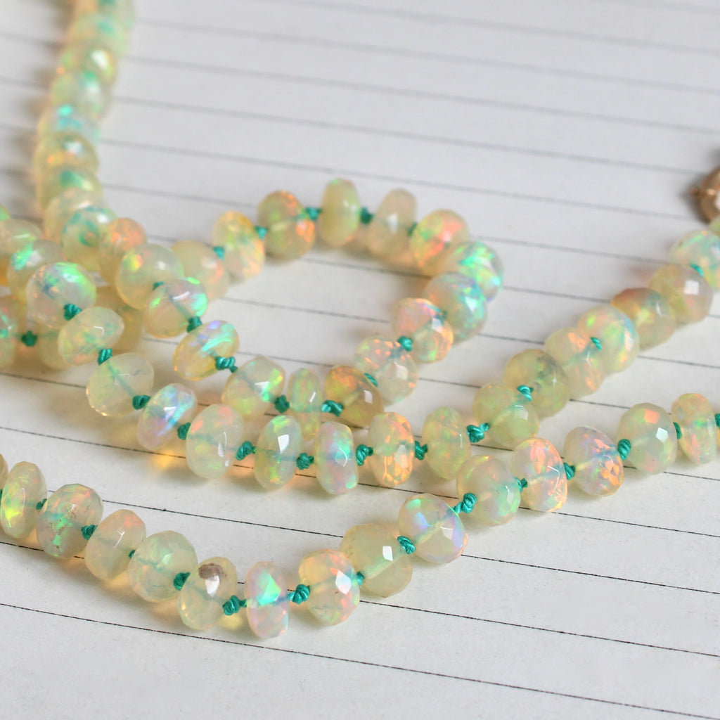 very colorful faceted opal beads knotted on emerald green silk with a gold bolt ring clasp