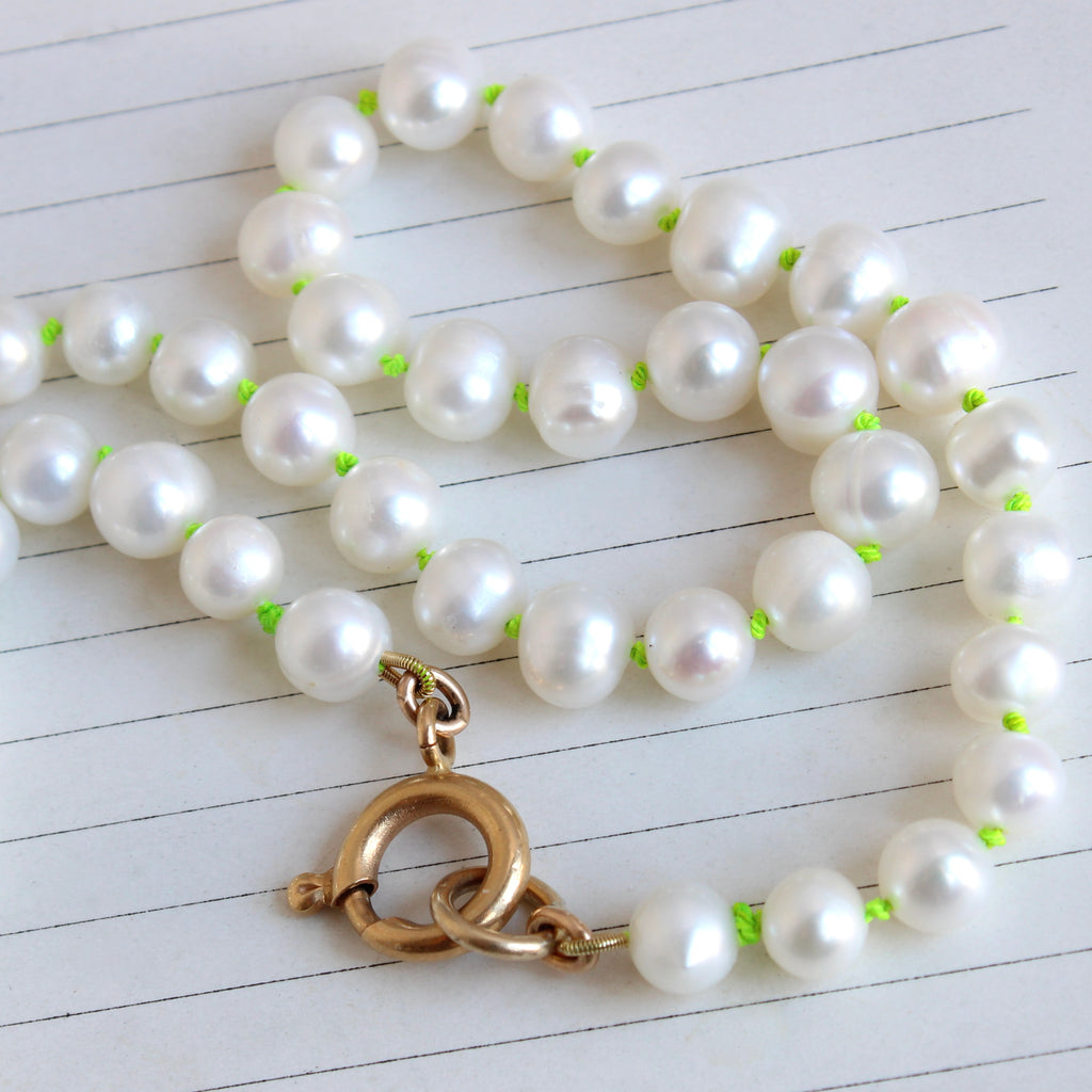 6.9 mm cultured pearls knotted on lime green silk with oversized gold bolt ring clasp