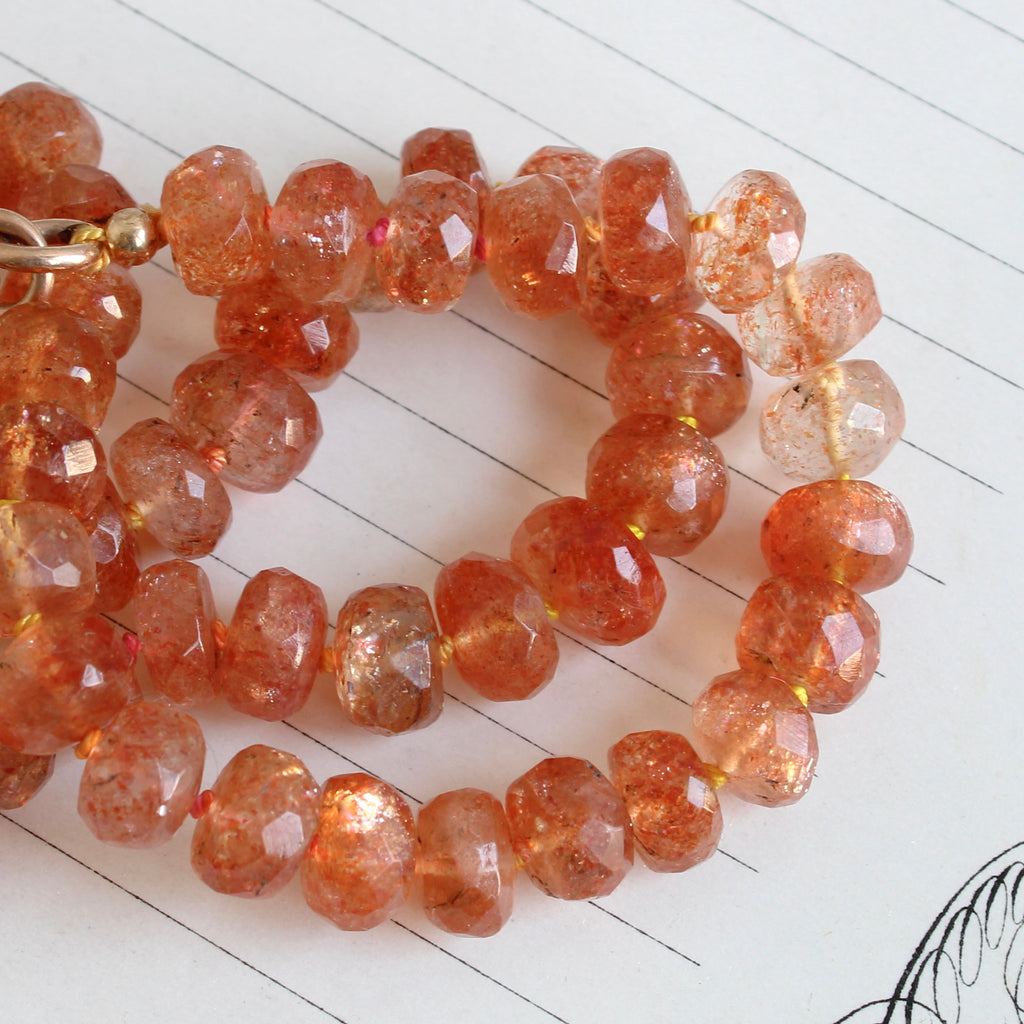 faceted orange sunstone beads with a gold clip clasp