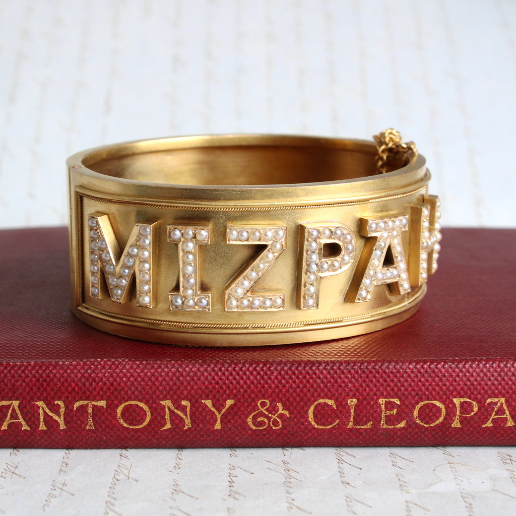wide yellow gold antique bangle bracelet with the word Mizpah across the front in letters set with seed pearls
