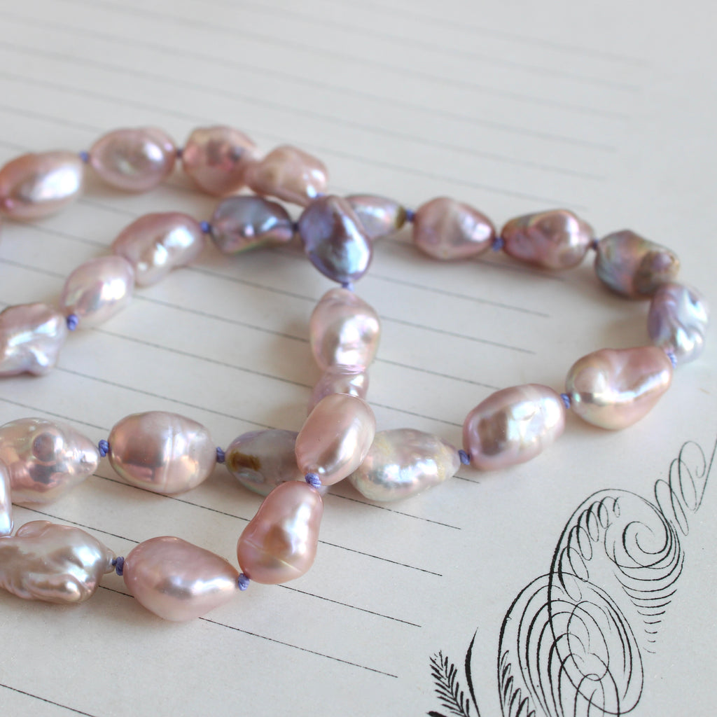 iridescent purple and pink freshwater irregular shaped pearls on lavender silk with gold clasp