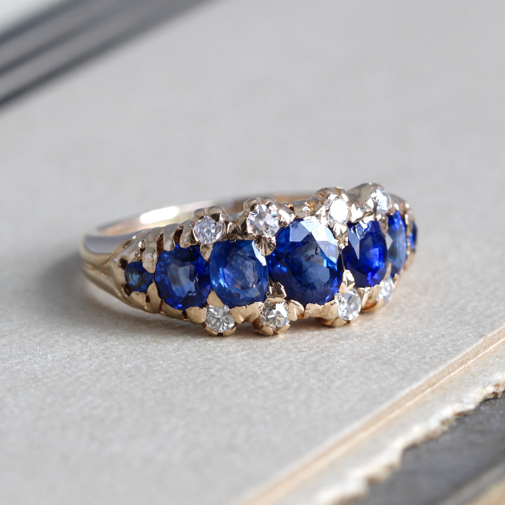 antique yellow gold ring with five cornflower blue sapphires and diamond accents