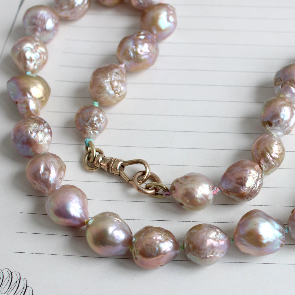 large irregular shaped pearls with pink and aqua irridescence and a gold clasp