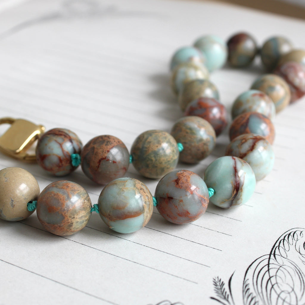 round jasper beads knotted on turquoise silk with a large gold clasp
