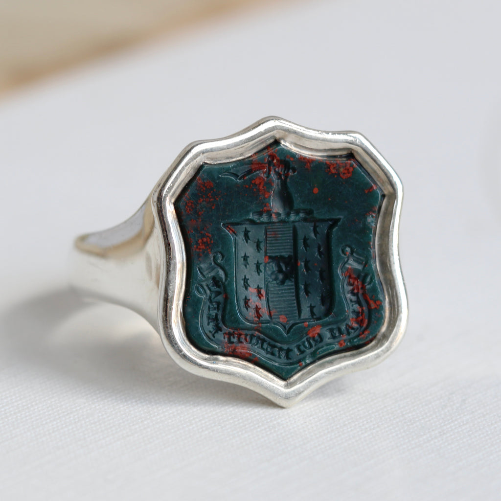 silver signet ring with shield shaped bloodstone carved with a lattin motto