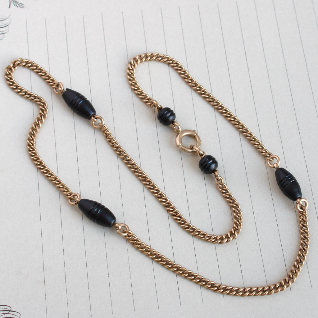 yellow gold curb chain with evenly spaced matte black glass bead stations