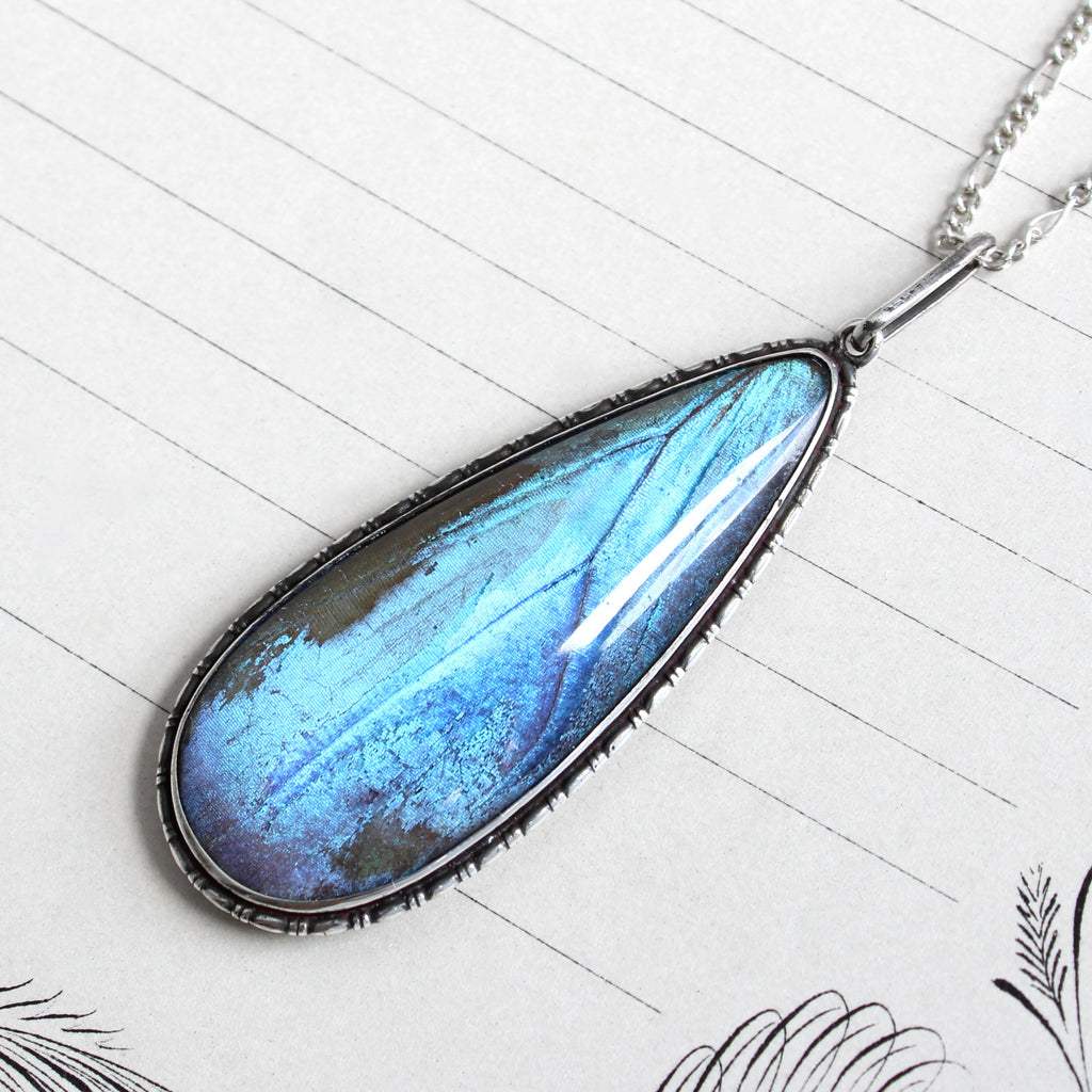 sterling pendant necklace with iridescent blue morpho butterfly wing encased in glass