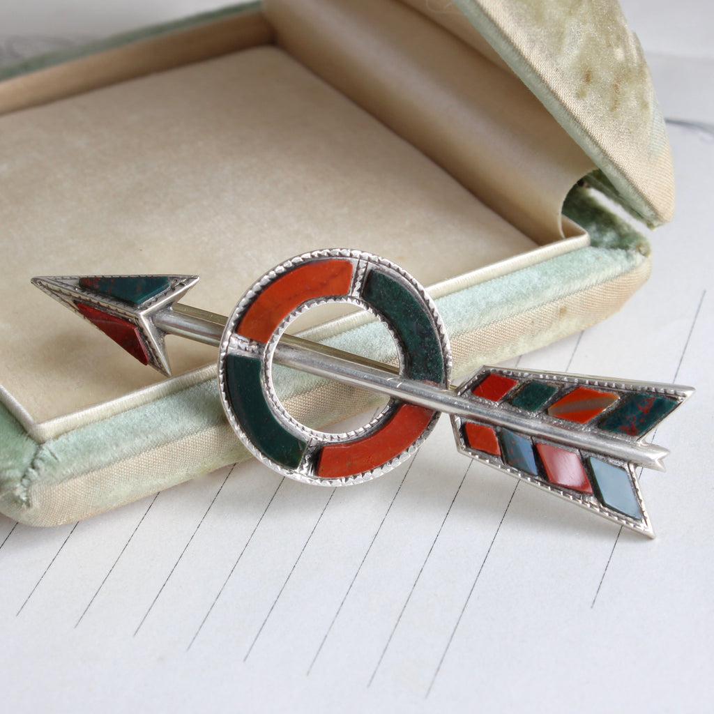 silver brooch designed as an arrow through a bullseye set with red jasper and bloodstone