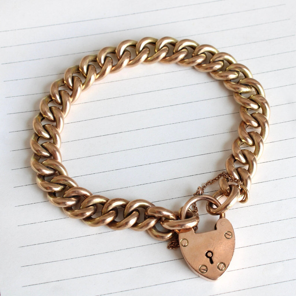 Antique 9k yellow gold curb chain bracelet with a heart shaped padlock as the closure.