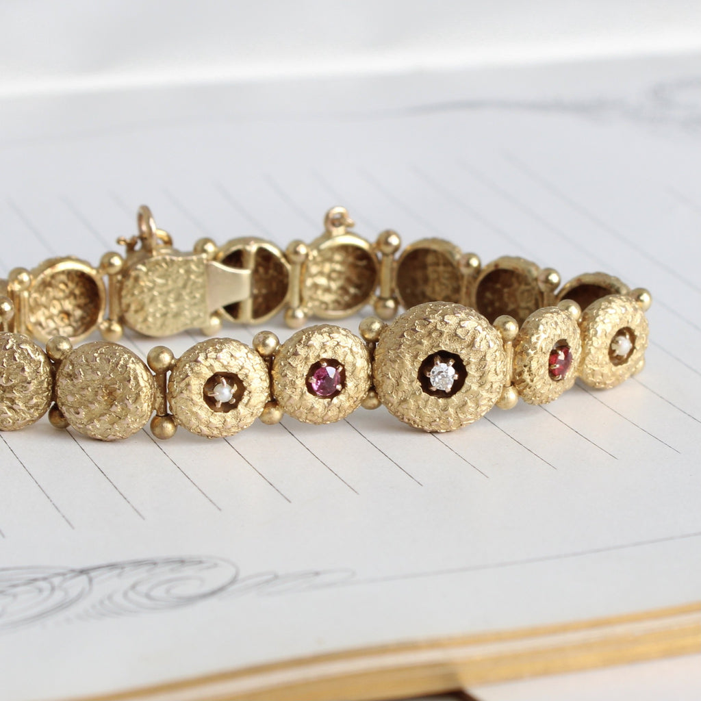 Antique yellow gold bracelet with circular textured links and set with rubies and diamonds.