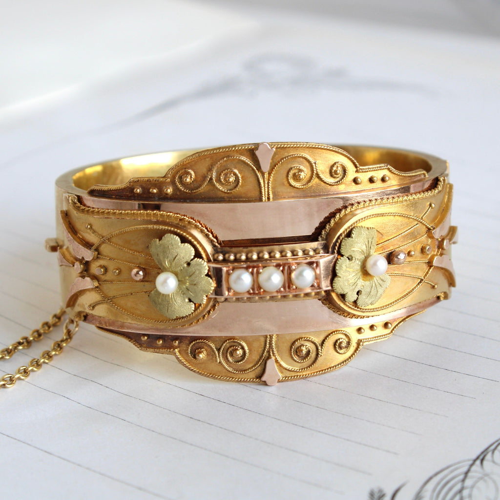 High karat gold antique bangle with applied scroll decoration and pearls