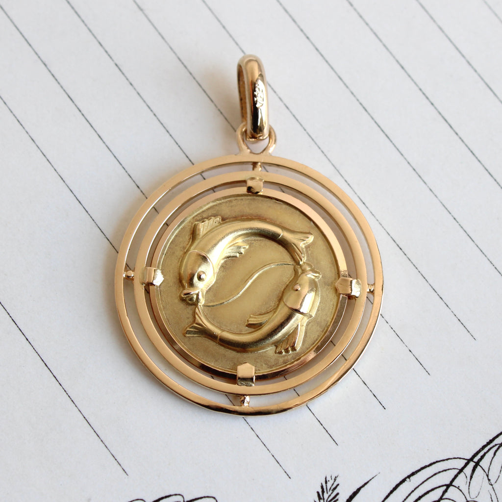 Vintage yellow gold coin charm with two fish embossed on the front to symbolize pisces. 