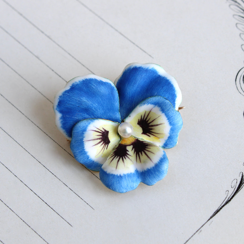 Vintage yellow gold and blue pansy pin with realistic enamel details and a pearl in the center.
