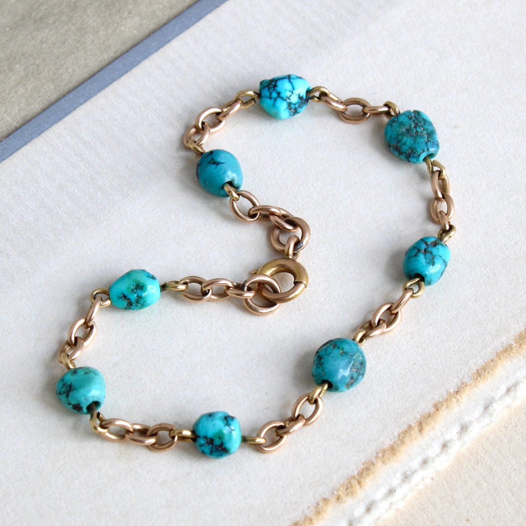 Antique yellow gold and blue turquoise nugget chain link bracelet with a spring clasp.