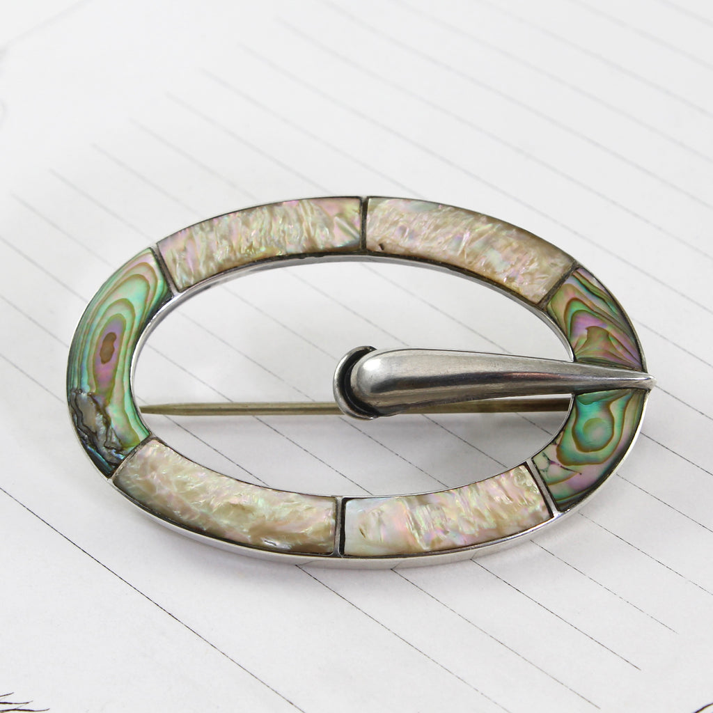 Antique sterling silver belt buckle shaped pin with mother of pearl and abalone inlay.
