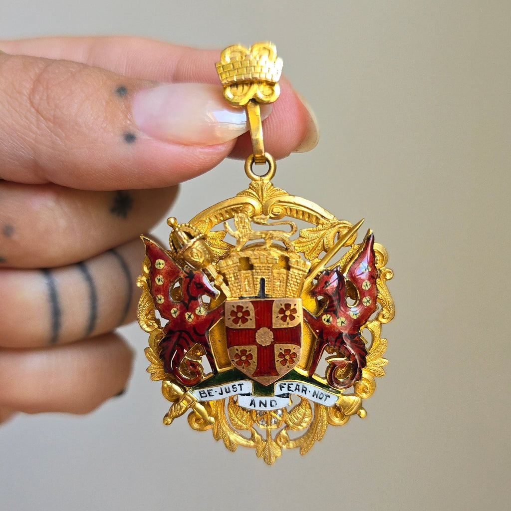 yellow gold medallion pendant decorated with two red dragons and a motto be just and fear not