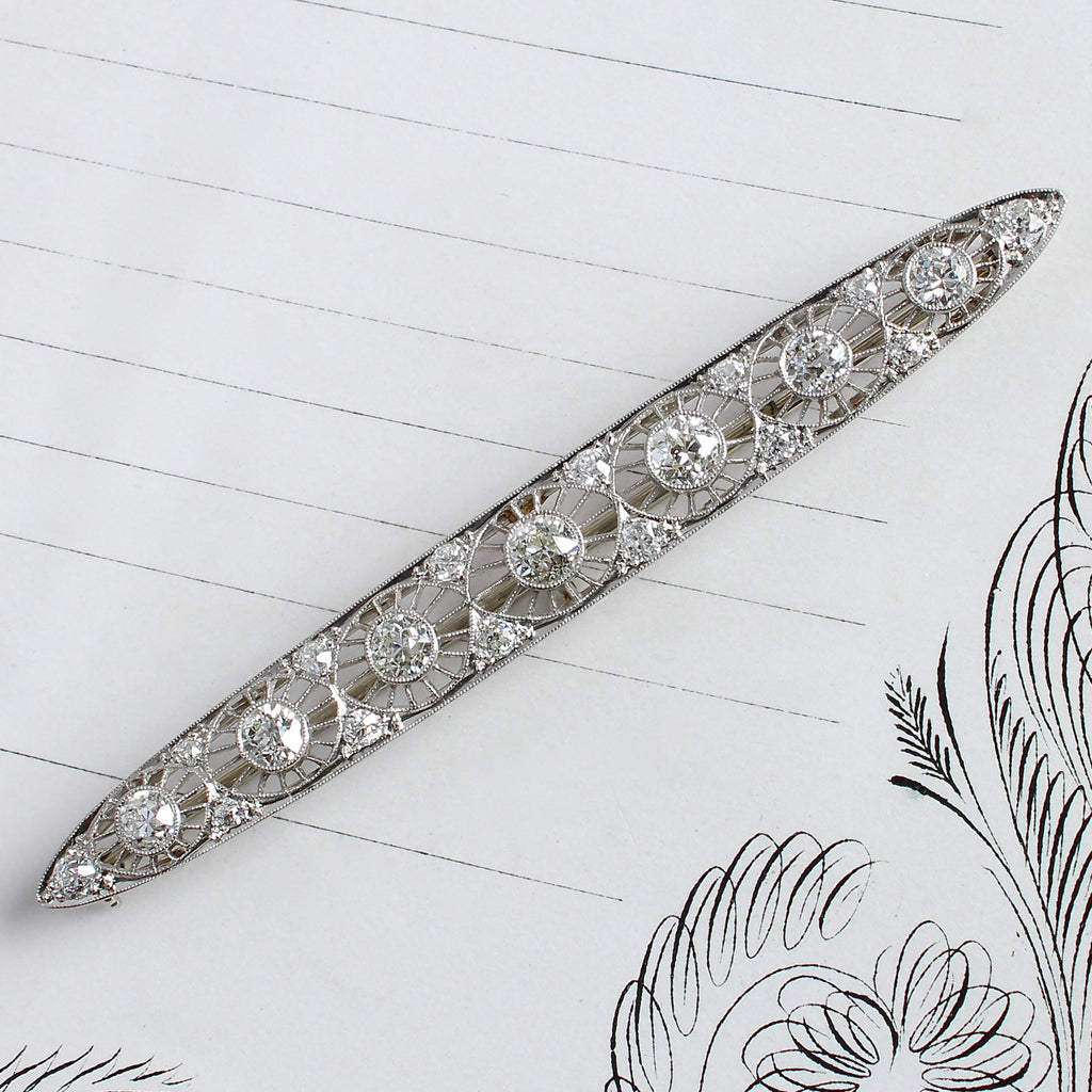 platinum bar brooch with seven filigree sunray design each one set with a very bright diamond and more diamonds along the edges