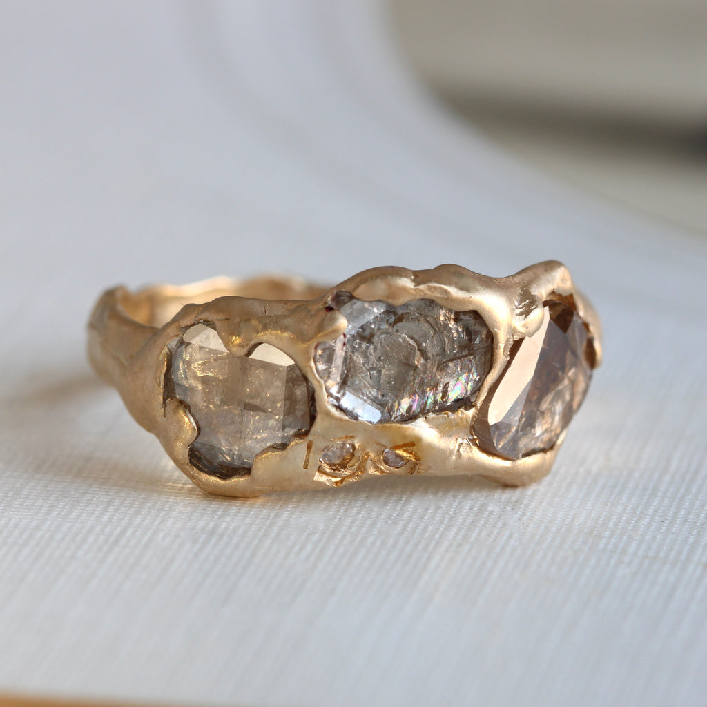 yellow gold ring in an organic nugget style set with large flat top rose cut diamonds that have a rustic salt and pepper clarity