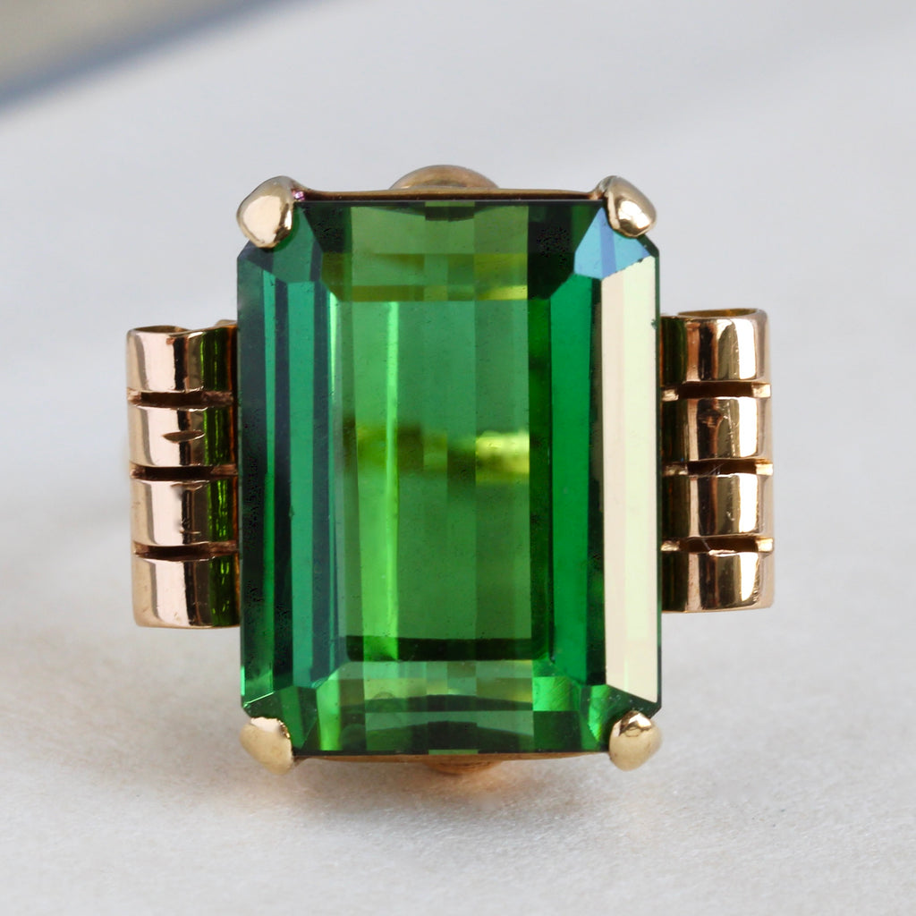large emerald cut green tourmaline in geometric gold art deco setting