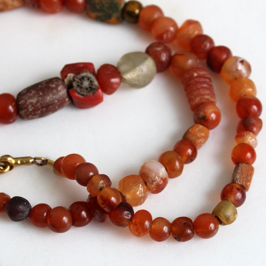 necklace of ancient roman beads mixed with 19th century carnelian and coral beads with a 22k clasp