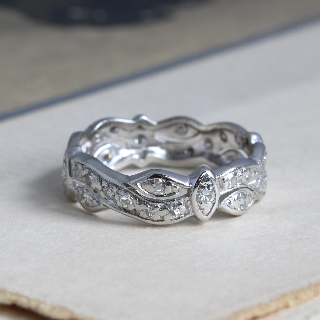 platinum band with scrolled details set with diamonds all around 