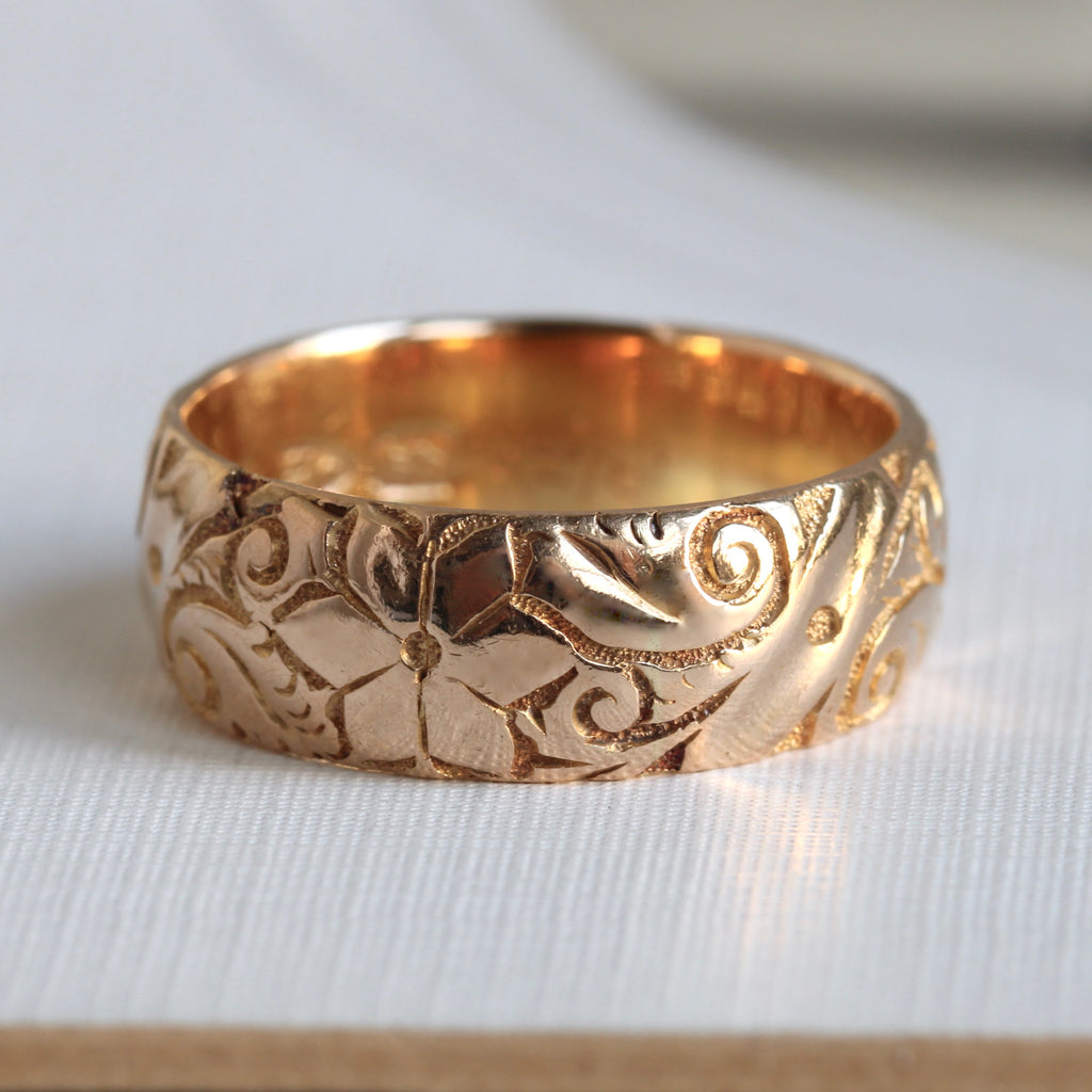 very deep yellow gold band engraved all around in a floral pattern, letter dated 1906