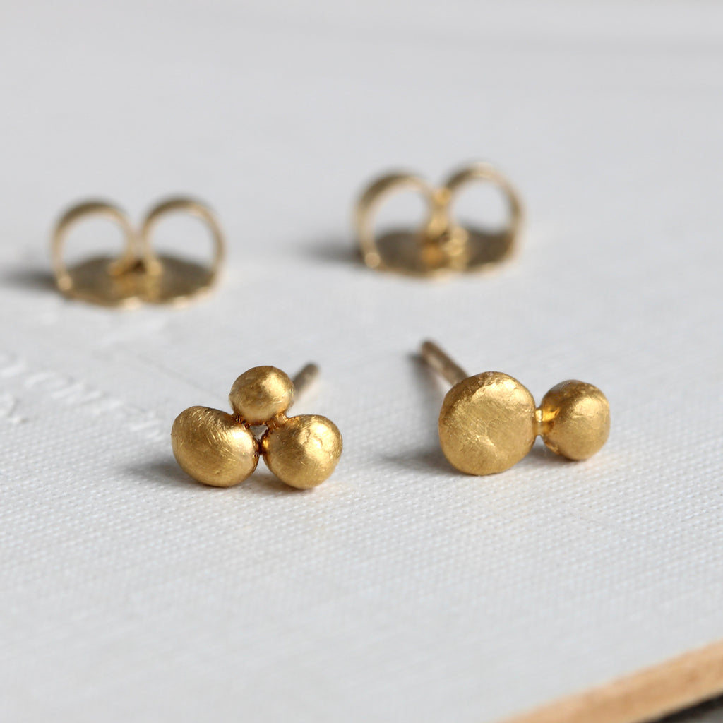 tiny 24k gold balls grouped together in twos and threes to make stud earrings