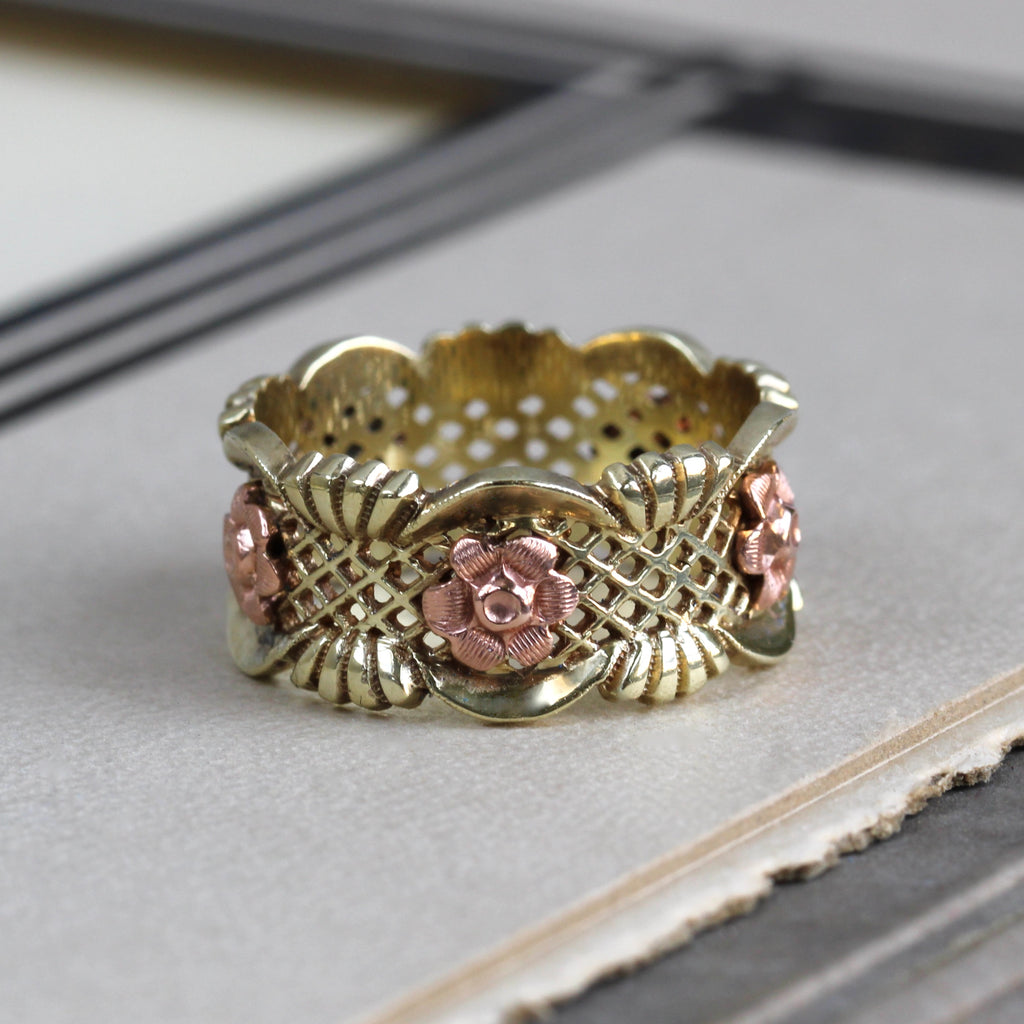 Vintage 14k yellow gold ring with a lattice motif studded with rose gold roses positioned eternity-style all round the band.