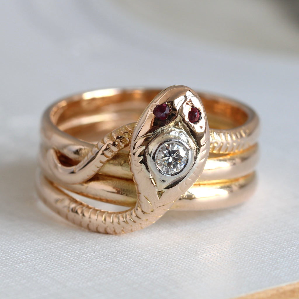 gold snake ring in a triple coil design with a diamond set in the head