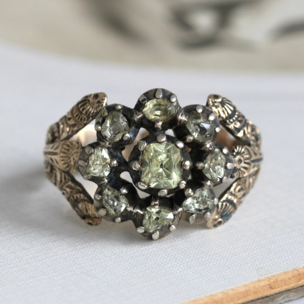 pale green gems set in a halo cluster in silver with a floral engraved gold hoop