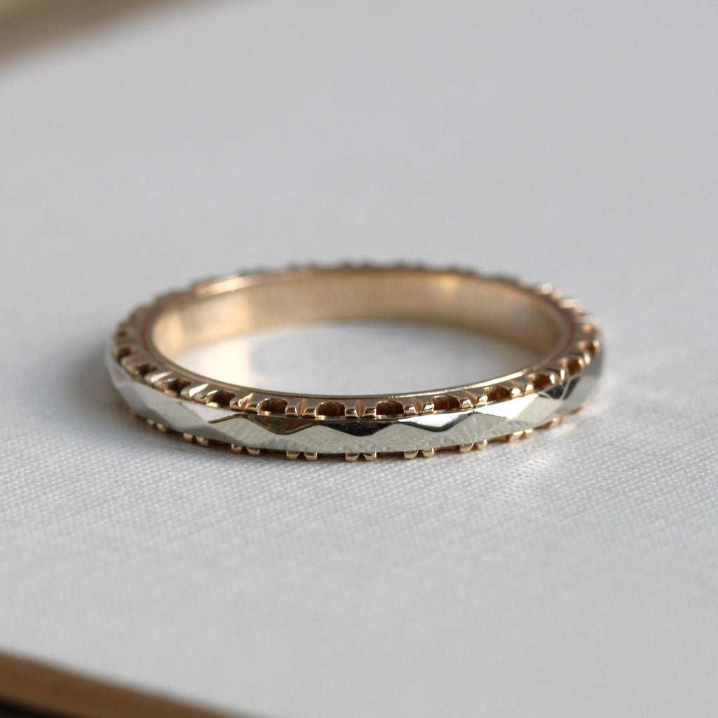 two tone gold wedding band with faceted white gold middle and yellow gold  prong design edges