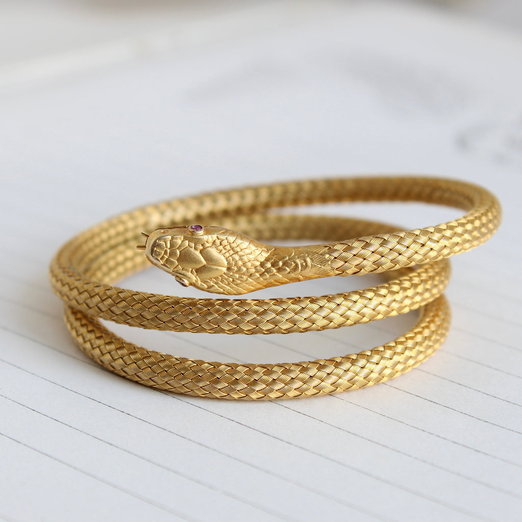 yellow gold snake bracelet designed to coil around the wrist made of finely woven gold mesh 