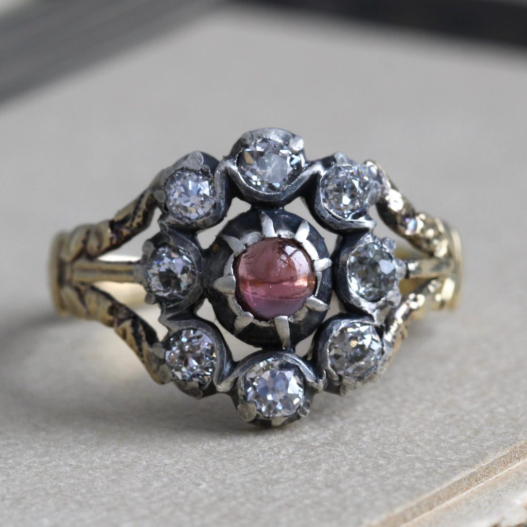 georgian ring with yellow gold band and a silver flower motif set with diamonds as petals and a garnet center