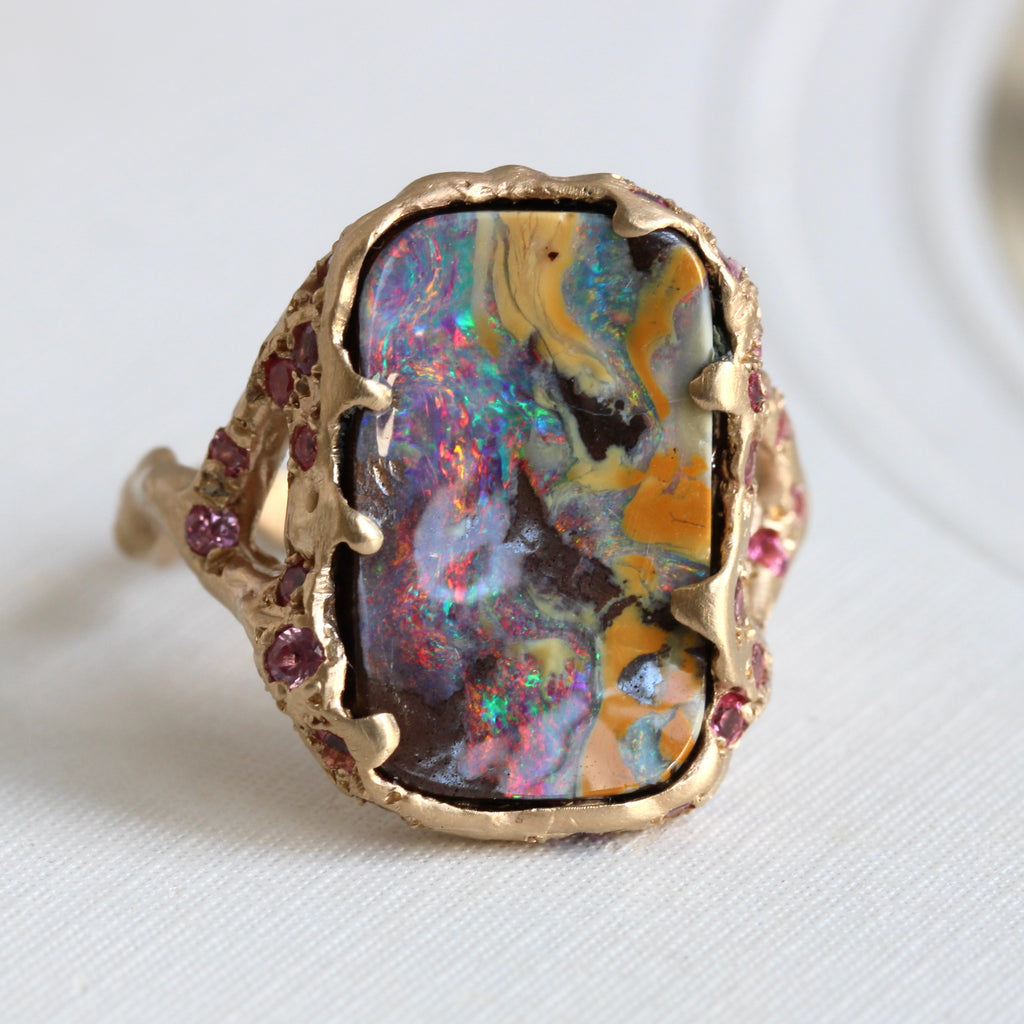 branch style rectangular boulder opal ring with bright pinks and greens in yellow gold with pink stone accents