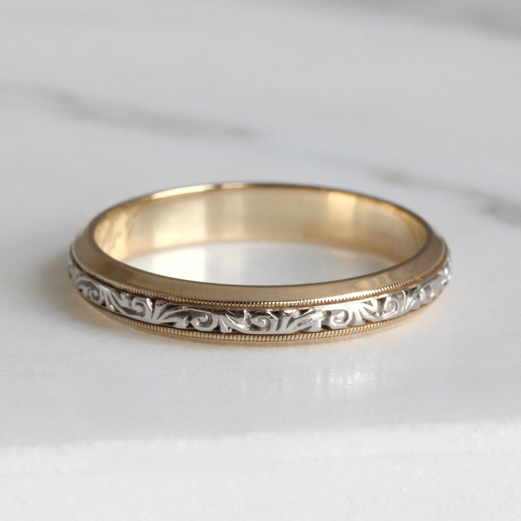 Gold ring with intricate design in white gold in the center