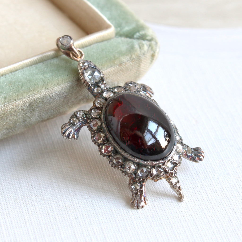 turtle pendant with a large garnet cabochon shell and rose cut diamond accents 