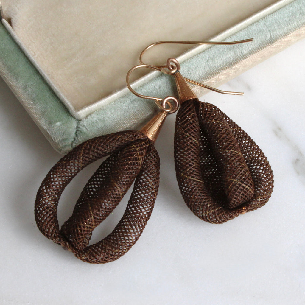 tear drop shaped earrings made of woven brown hair with gold fittings