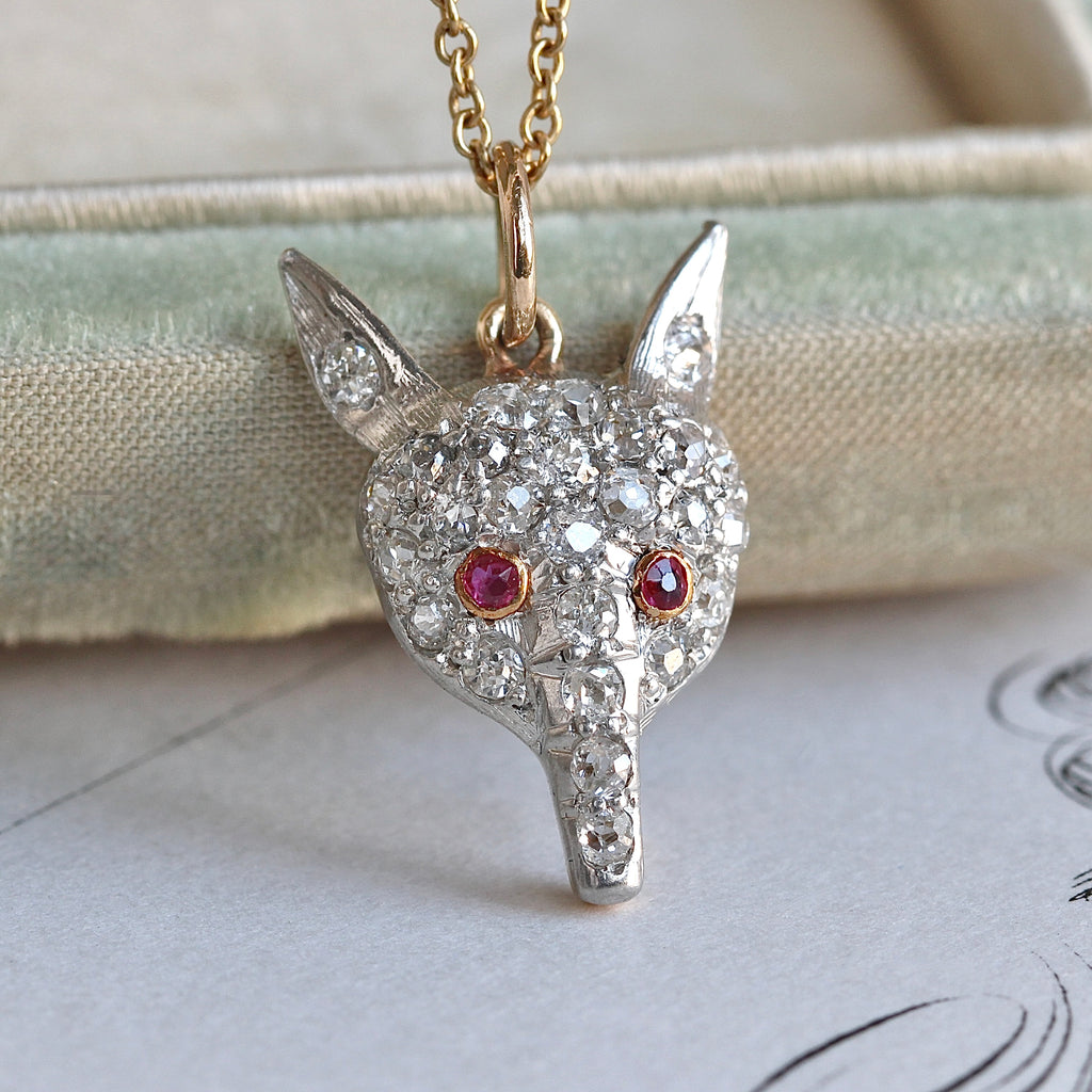 platinum fox charm set with old cut diamonds and ruby eyes, on a gold chain