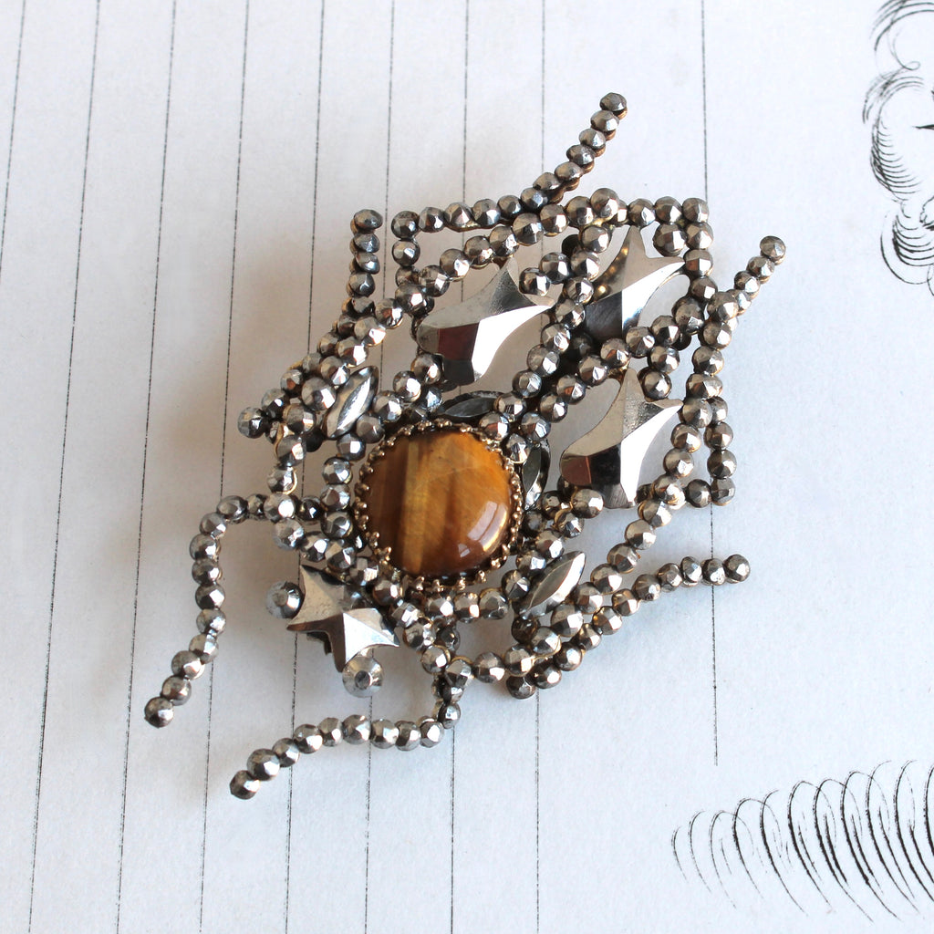 beetle brooch made of cut steel rivets with a tigers eye body