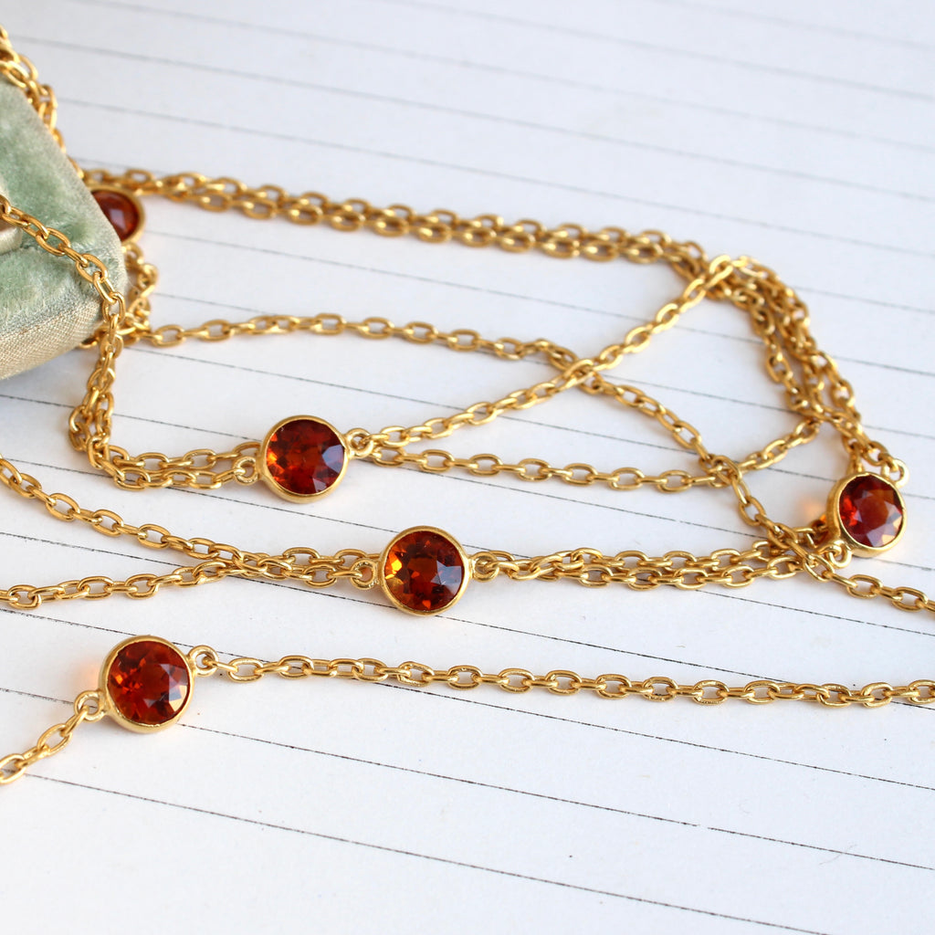 high karat gold cable chain with six deep orangey gold citrine gems in bezels at intervals along the length.