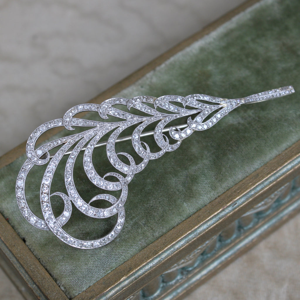 white gold brooch designed as a feather completely studded with diamonds
