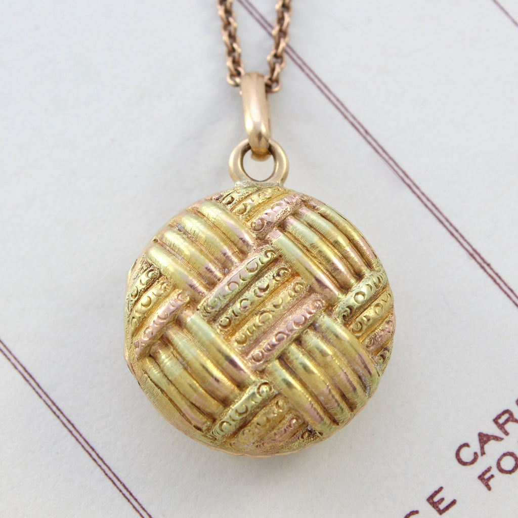 Antique 14k yellow and rose gold locket designed in a round shape with basket weave design, accented and delicate embossed texture.