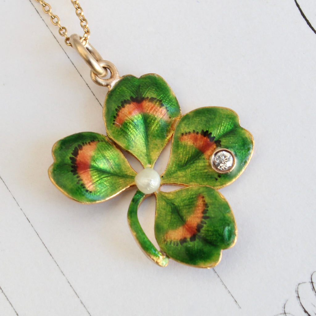 antique gold 4 leaf clover pendant enameled in green and rust with an old cut diamond accent and a pearl in the center, on a gold chain