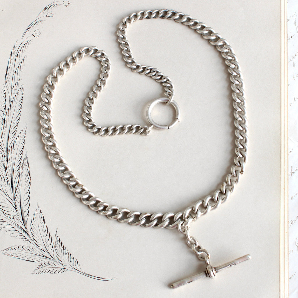 thick silver curb chain necklace with graduated links and a watch chain t-bar.