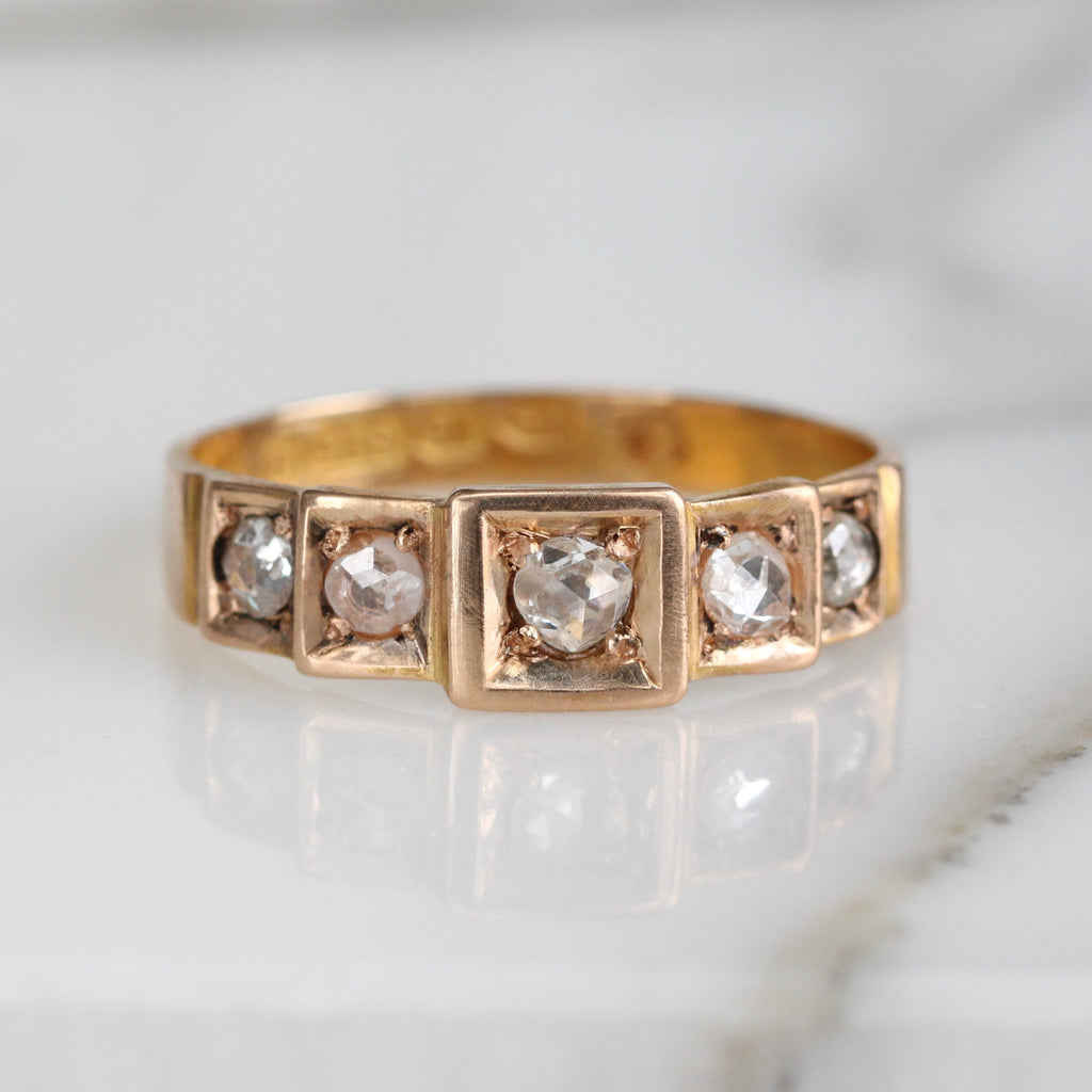 yellow gold band style ring set with five rough cut diamonds across the front